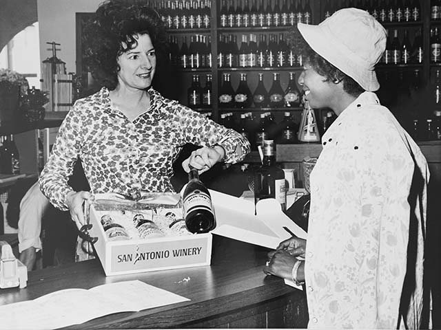 Historical photo of Maddalena Riboli selling wine to customer in tasting room